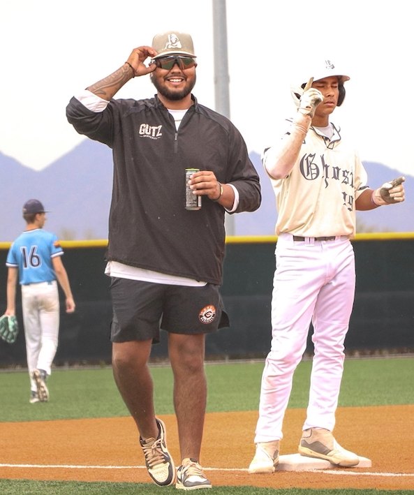 Coach Gutz smiling in the third base coaching box